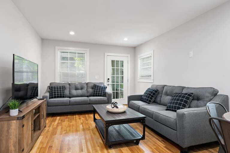 A seamless flow from the living room to the kitchen, highlighted by sleek, modern decor and a comfortable seating area perfect for socializing and relaxation.