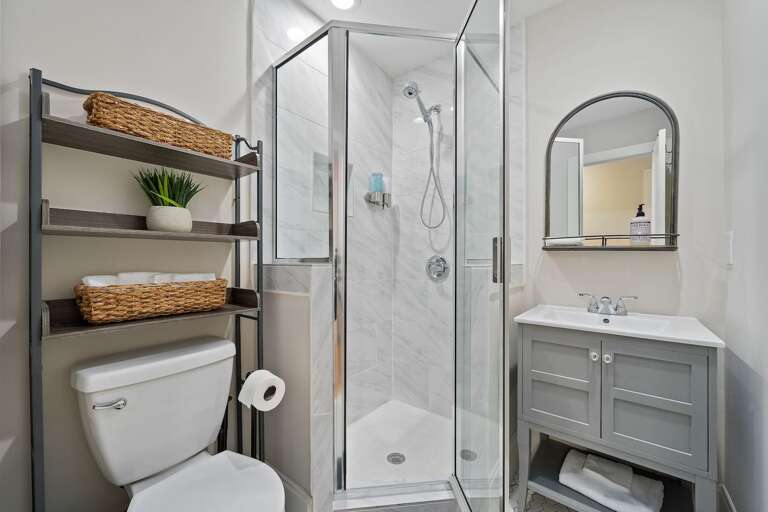 Modern and elegant, this bathroom is equipped with a glass-enclosed shower and contemporary fixtures, perfect for a refreshing start or relaxing end to your day.
