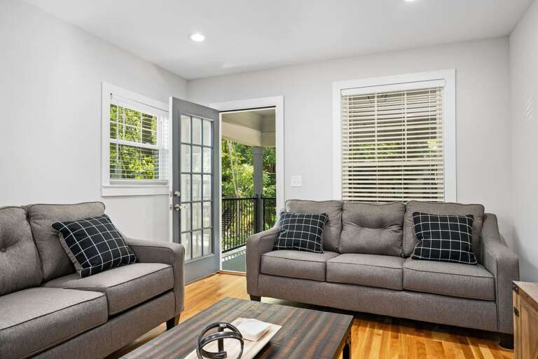 Featuring stylish furnishings and direct access to a private balcony, this living room blends indoor comfort with outdoor appeal.