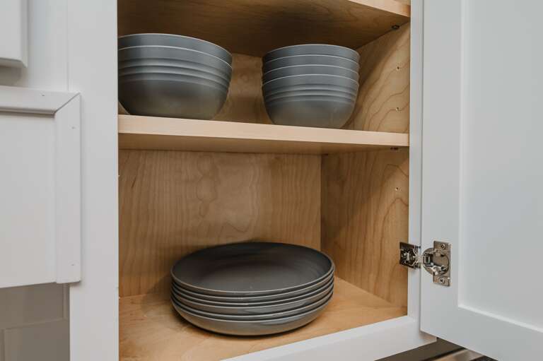 Neatly organized dishes and glassware ready for your dining needs, showcasing the unit’s attention to detail and convenience.