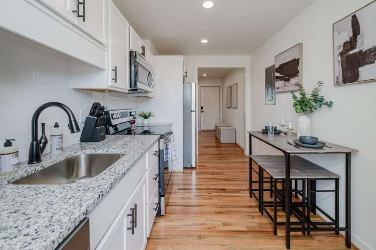 View the sleek kitchen from the dining area, perfect for social cooking and dining. View the sleek kitchen from the dining area, perfect for social cooking and dining.