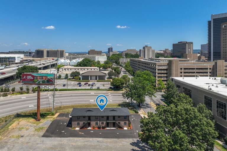 A wider aerial shot displaying the property's strategic location within the bustling cityscape.