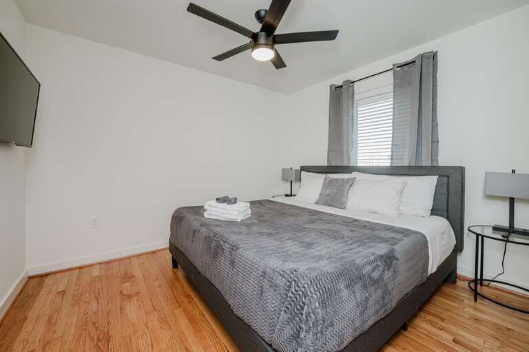 Spacious and inviting bedroom with modern decor and ceiling fan for a comfortable stay.