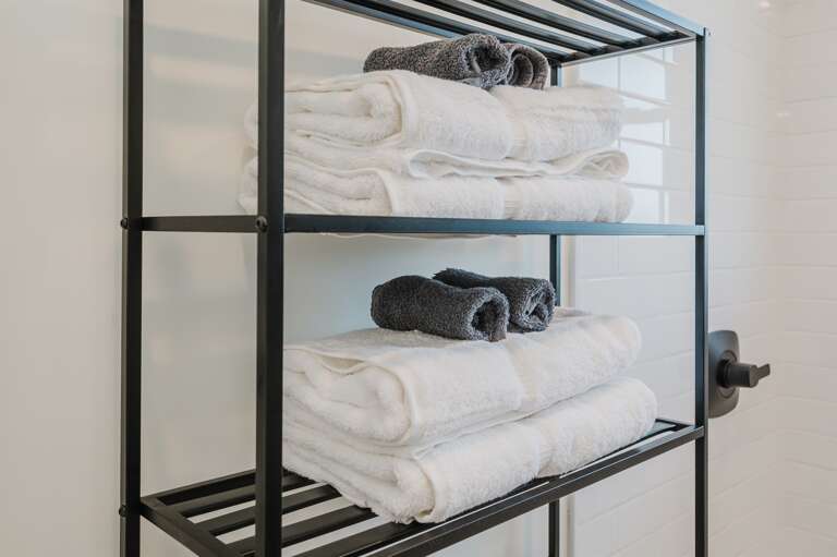 Conveniently organized towels in the bathroom, ensuring easy access and a tidy space. Conveniently organized towels in the bathroom, ensuring easy access and a tidy space.