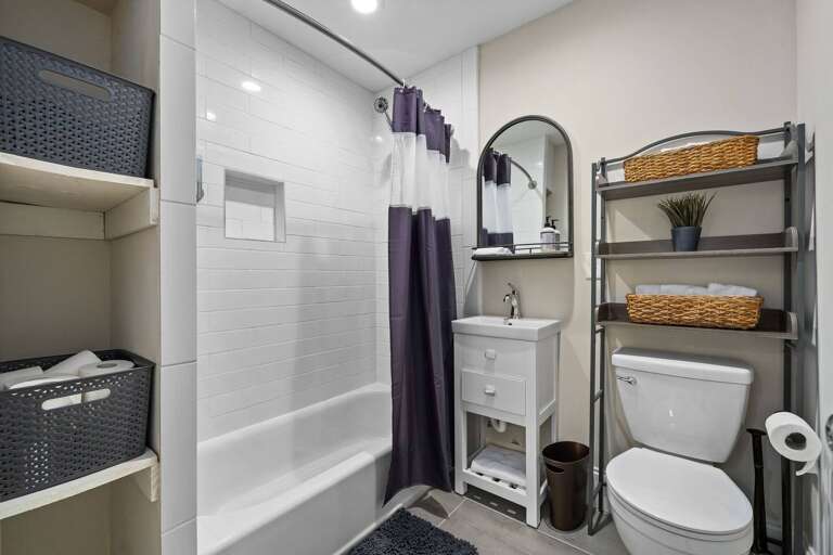 Modern and sleek, equipped with a contemporary tub and shower and essential amenities. 