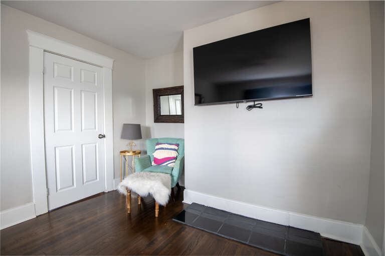 Cozy corner with a mounted TV and a small seating area for relaxation Cozy corner with a mounted TV and a small seating area for relaxation