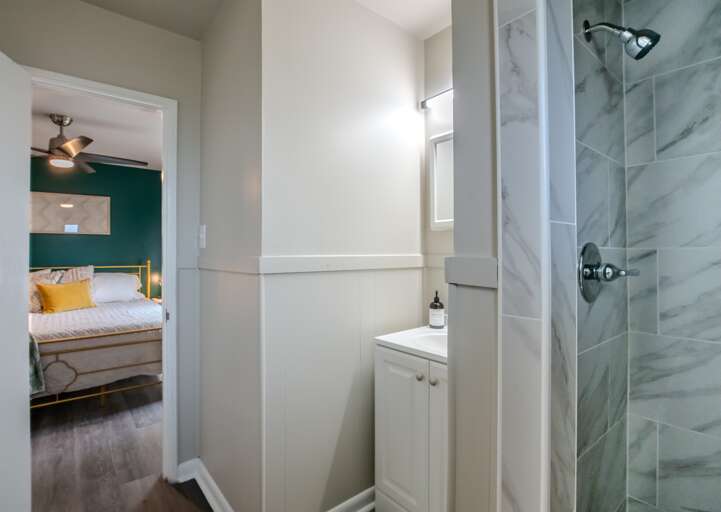 Luxurious walk-in shower with high-end marble tiling and glass enclosure.