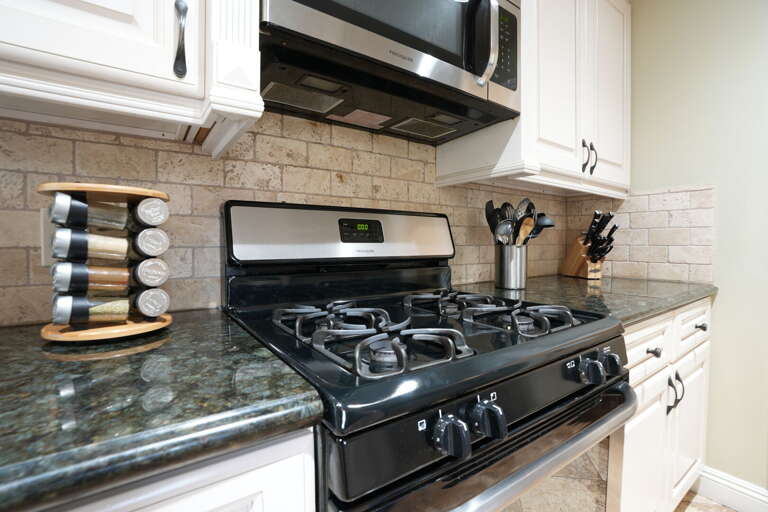 Kitchen Corner Showcasing Stove And Spices In Vacation Rental