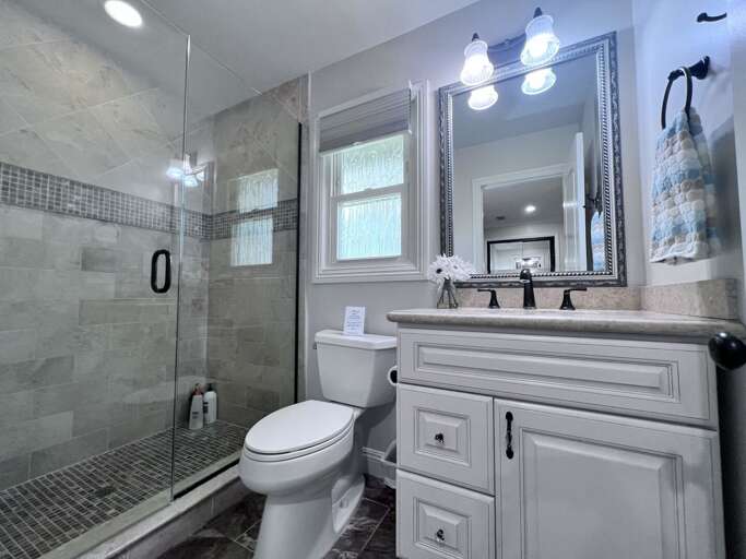 Vacation Rental Bathroom With A Glass Shower And Vanity Mirror