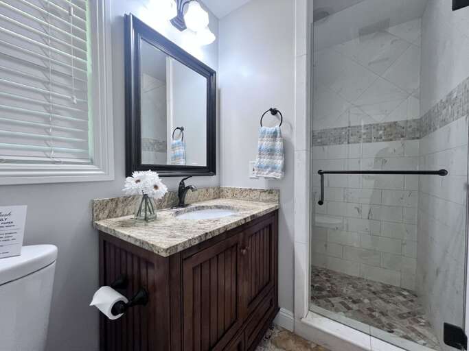 Marble-adorned Bathroom With Brown Cabinet