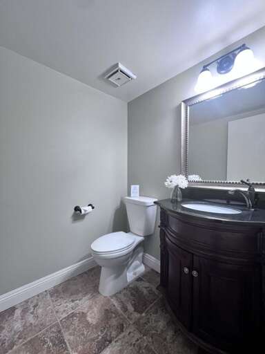 Basic Bathroom With Beige Walls, Vanity Mirror, And Tiled Floor Basic Bathroom With Beige Walls, Vanity Mirror, And Tiled Floor