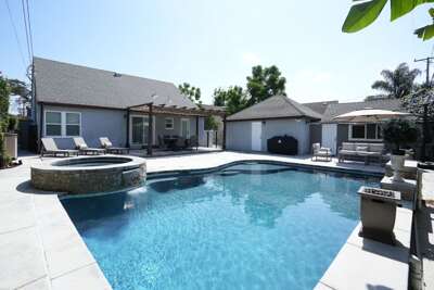 Outdoor dining table, living set and chaise loungers along side beautiful pool.