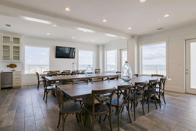 Dining Area with 3, 12 ft dining tables and 65 inch flat screen.