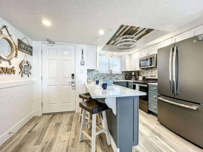 Our kitchen boasts new appliances and a breakfast bar, perfect for culinary adventures with ocean views