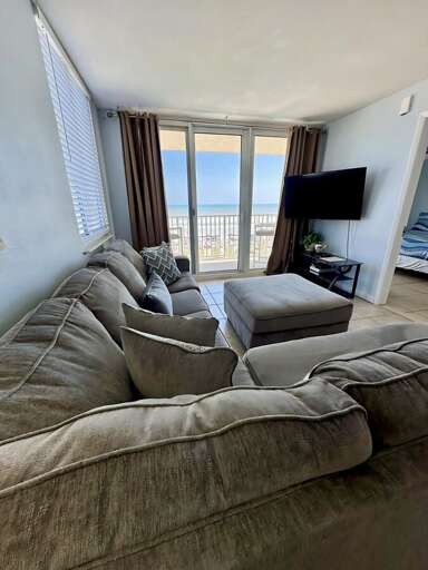 Stretch out on the sectional and enjoy panoramic ocean views through floor-to-ceiling windows, complete with a wall-mounted TV for movie nights. Stretch out on the sectional and enjoy panoramic ocean views through floor-to-ceiling windows, complete with a wall-mounted TV for movie nights.
