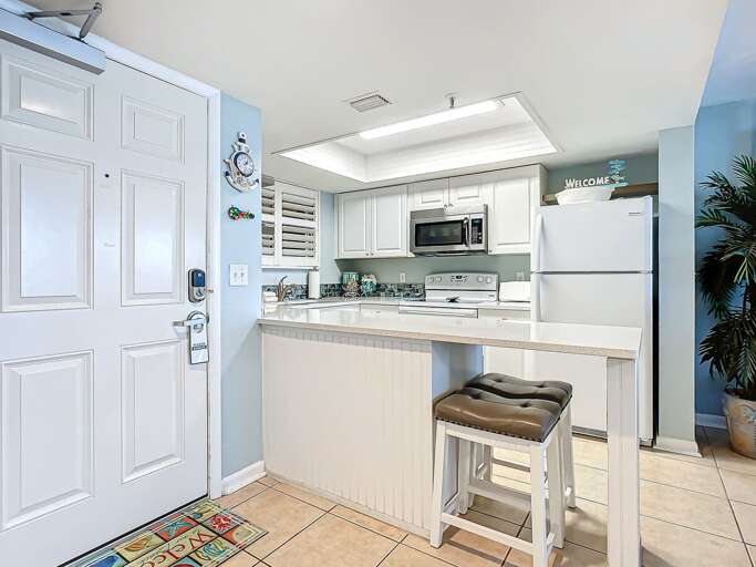 Bright Kitchen Space With Bar Stools And White Appliances Bright Kitchen Space With Bar Stools And White Appliances