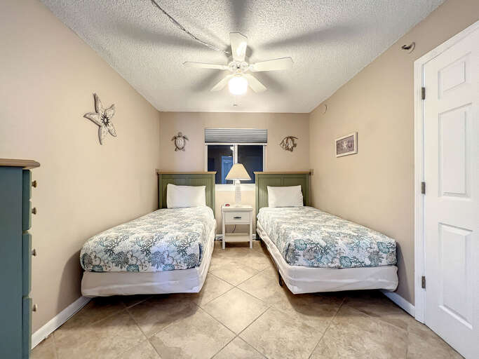 Twin beds with ceiling fan above.
