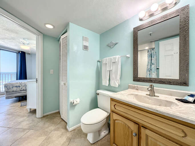 Vanity with storage and full size toilet. Access to master bedroom.
