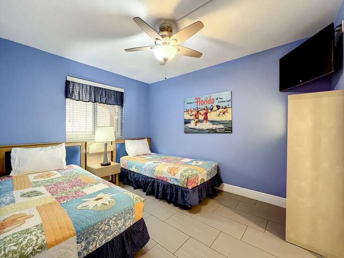2 Twins with ceiling fan. TV in room.