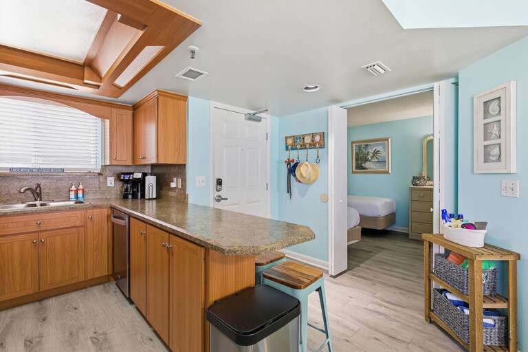 Fully equipped kitchen with granite countertops, breakfast bar seating, and open flow to living