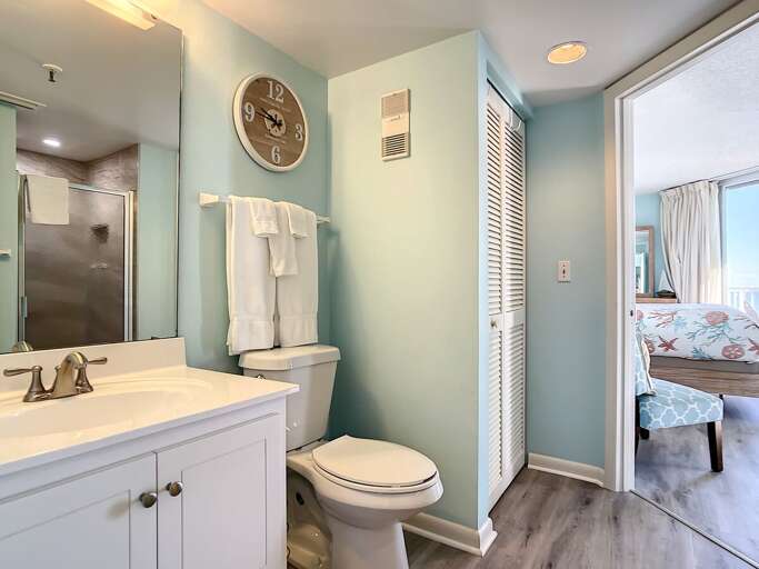 Vanity with storage. Closet for extra storage and walk in shower.
