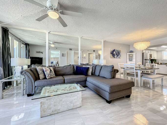 Coffee table in front of the couch. Ceiling fan above.