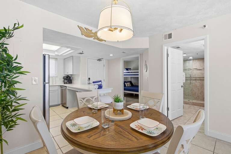 Gather for meals in this charming beach stay dining area with easy access to a full kitchen and