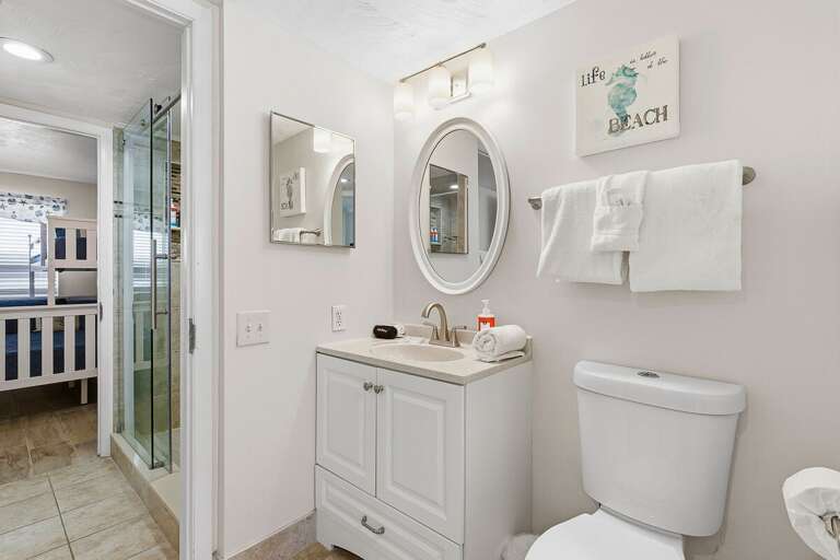 Refresh during your beach stay in this bright bathroom featuring a modern vanity, fresh towels, and a walk-in shower. Clean, comfortable, and conveniently located near sleeping areas.