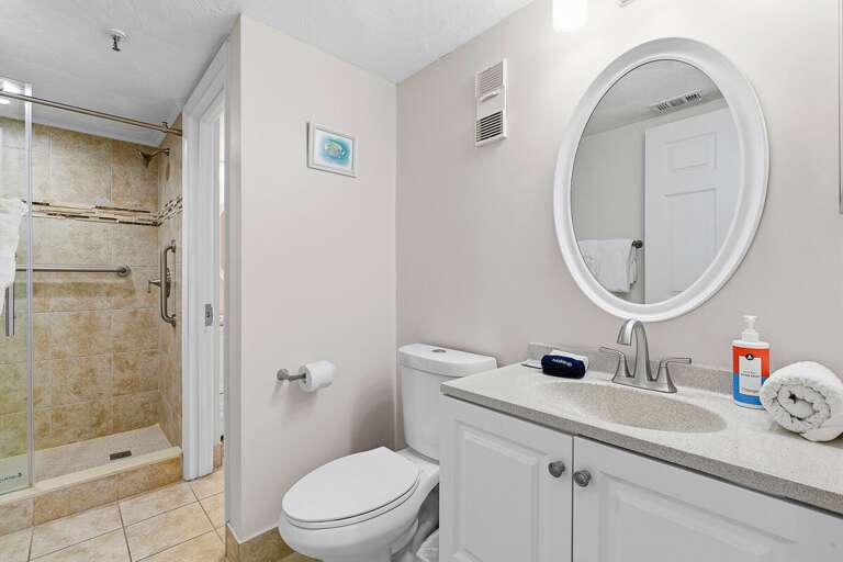 Refresh during your beach stay in this clean, modern bathroom featuring a spacious walk-in shower, updated vanity, and fresh linens. A comfortable space to unwind after a day by the ocean.