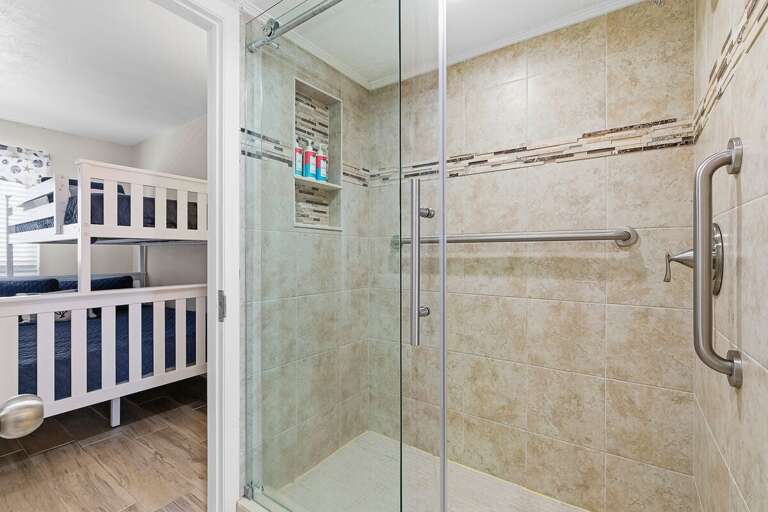 Refresh during your beach stay in this spacious walk-in shower with modern tile and glass enclosure. Conveniently located near the bunk room, offering comfort and easy access for guests.