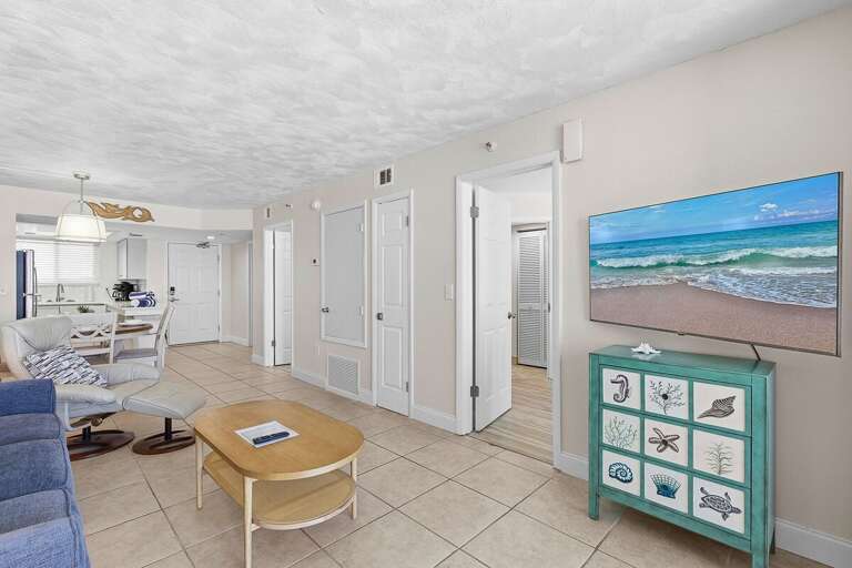 Unwind in this comfortable beach stay living area featuring cozy seating, a flat-screen TV, and open