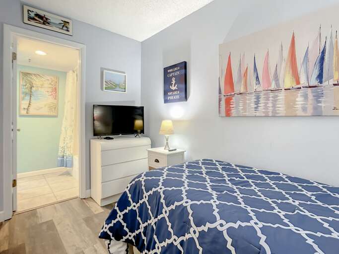 Dresser for storage. TV in bedroom and access to the guest bathroom.