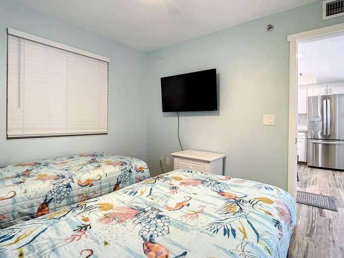 Nightstand and mounted TV in bedroom.