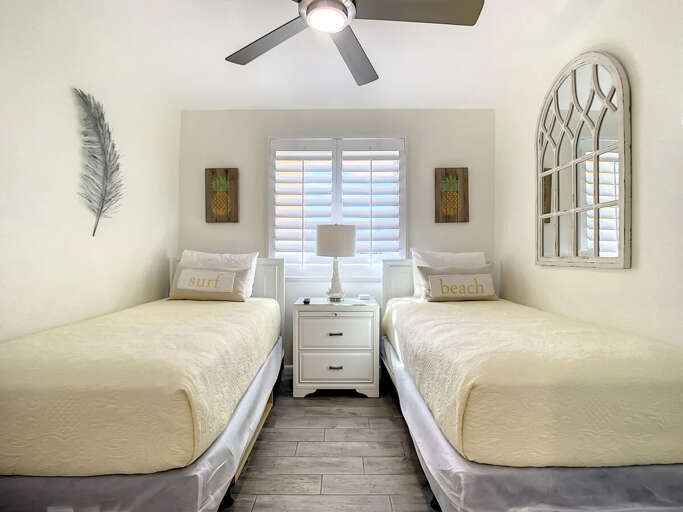 2 twin beds with nightstand and ceiling fan. 2 twin beds with nightstand and ceiling fan.