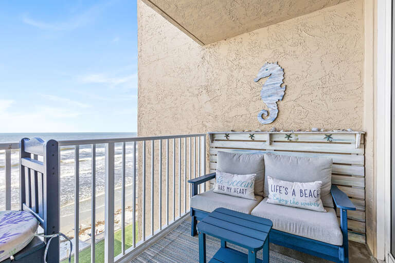 Soak in picturesque ocean views from a balcony adorned with coastal-inspired decor and comfortable furniture.