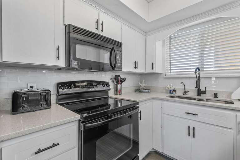 This beautifully designed kitchen features a stylish black and white color palette. The sleek black This beautifully designed kitchen features a stylish black and white color palette. The sleek black