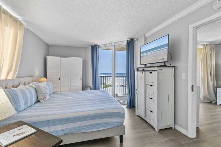 The room is bathed in natural light from the large windows, which frame the beautiful coastal The room is bathed in natural light from the large windows, which frame the beautiful coastal