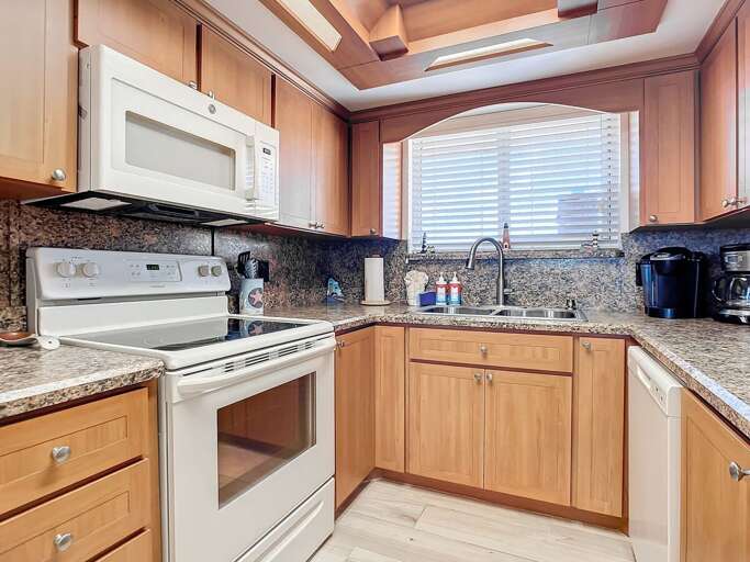 Bright, Beige Kitchen With Built-in Appliances, Granite Countertops In A Vacation Rental