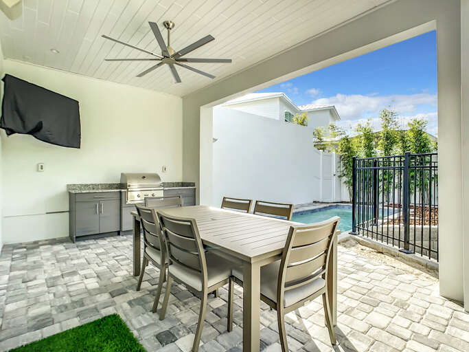 Our patio oasis boasts a charming table with chairs, perfect for enjoying meals or engaging in friendly games under the breeze of the fan.