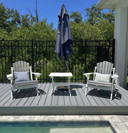 Relax and unwind on the private deck with cozy Adirondack chairs, a shaded umbrella, and peaceful views — the perfect spot for your morning coffee or evening drink.