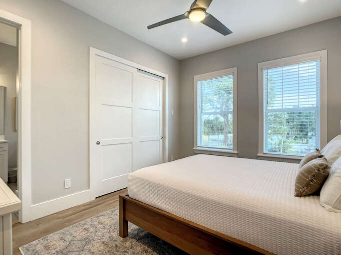Unwind in comfort with a queen bed, dresser, nightstand, and ceiling fan, ensuring a serene retreat.
