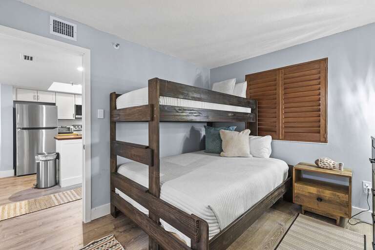This charming bedroom features rustic wooden bunk beds and soft linens, perfect for a relaxing