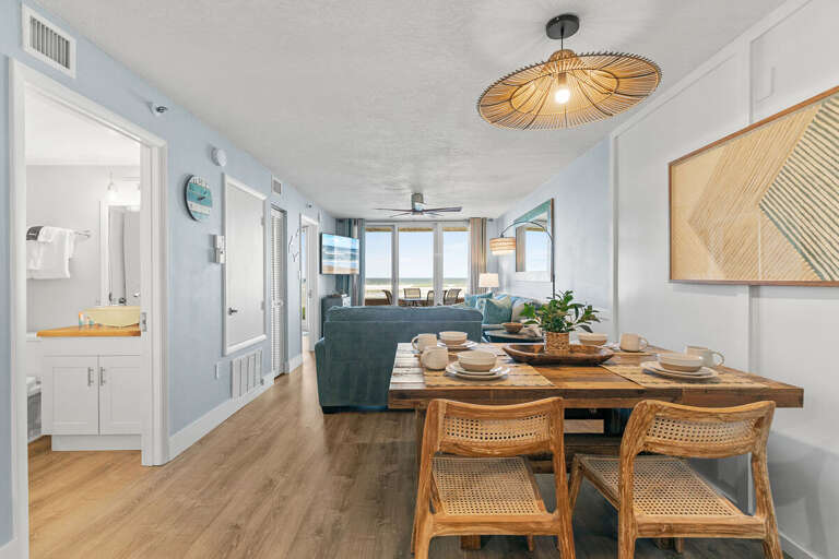 This coastal-inspired living and dining space features natural wood furnishings, stylish décor, and