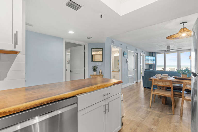 This inviting open-concept living space features a natural wood dining set, cozy seating, and