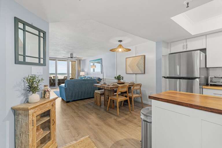 This open-concept space features a rustic dining area, a modern kitchen with stainless steel