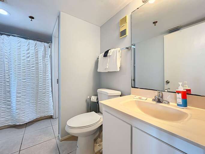 This modern bathroom features a spacious shower, bright lighting, and essential amenities for a refreshing and comfortable experience.