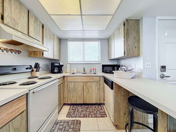 This thoughtfully designed kitchen features essential appliances, ample counter space, and a cozy atmosphere, perfect for preparing meals during your seaside getaway.