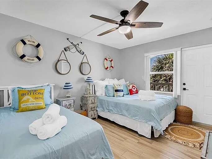 Bright, nautical-themed bedroom with a Queen and a Twin Single Bed featuring a fun coastal decor, and plenty of natural light—perfect for a restful beach getaway! Bright, nautical-themed bedroom with a Queen and a Twin Single Bed featuring a fun coastal decor, and plenty of natural light—perfect for a restful beach getaway!