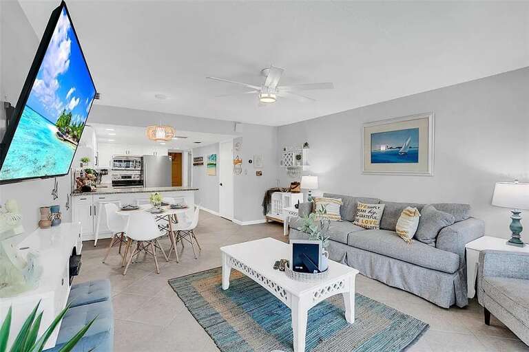 A bright open-concept living space—featuring a comfy sofa, smart TV, and a fully equipped kitchen perfect for relaxing after a beach day. A bright open-concept living space—featuring a comfy sofa, smart TV, and a fully equipped kitchen perfect for relaxing after a beach day.