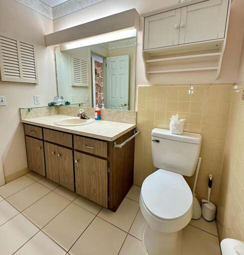 Clean and spacious bathroom featuring a wide vanity with ample counter space, large mirror, and Clean and spacious bathroom featuring a wide vanity with ample counter space, large mirror, and